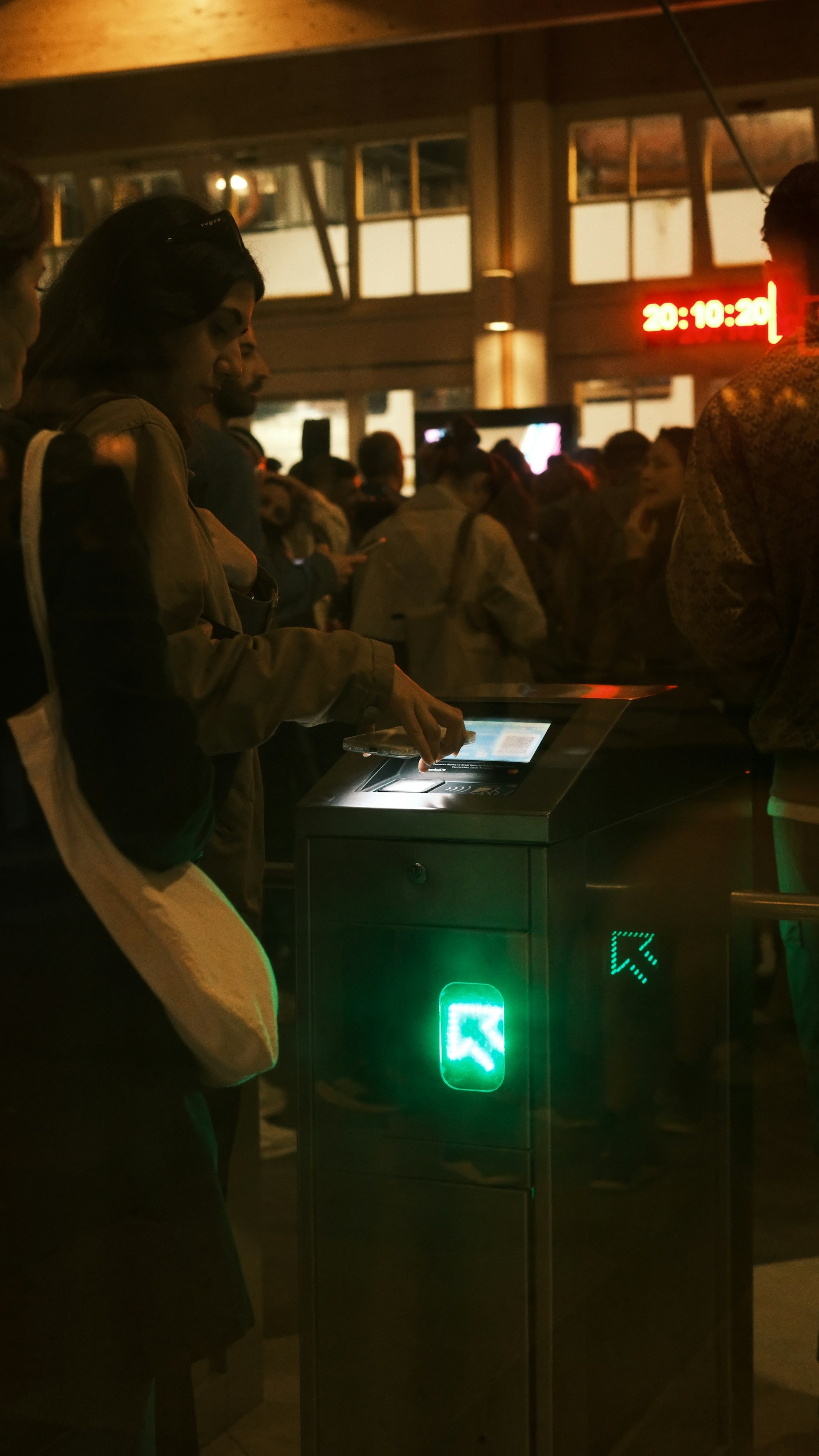 Woman using a ticket gate with green light
