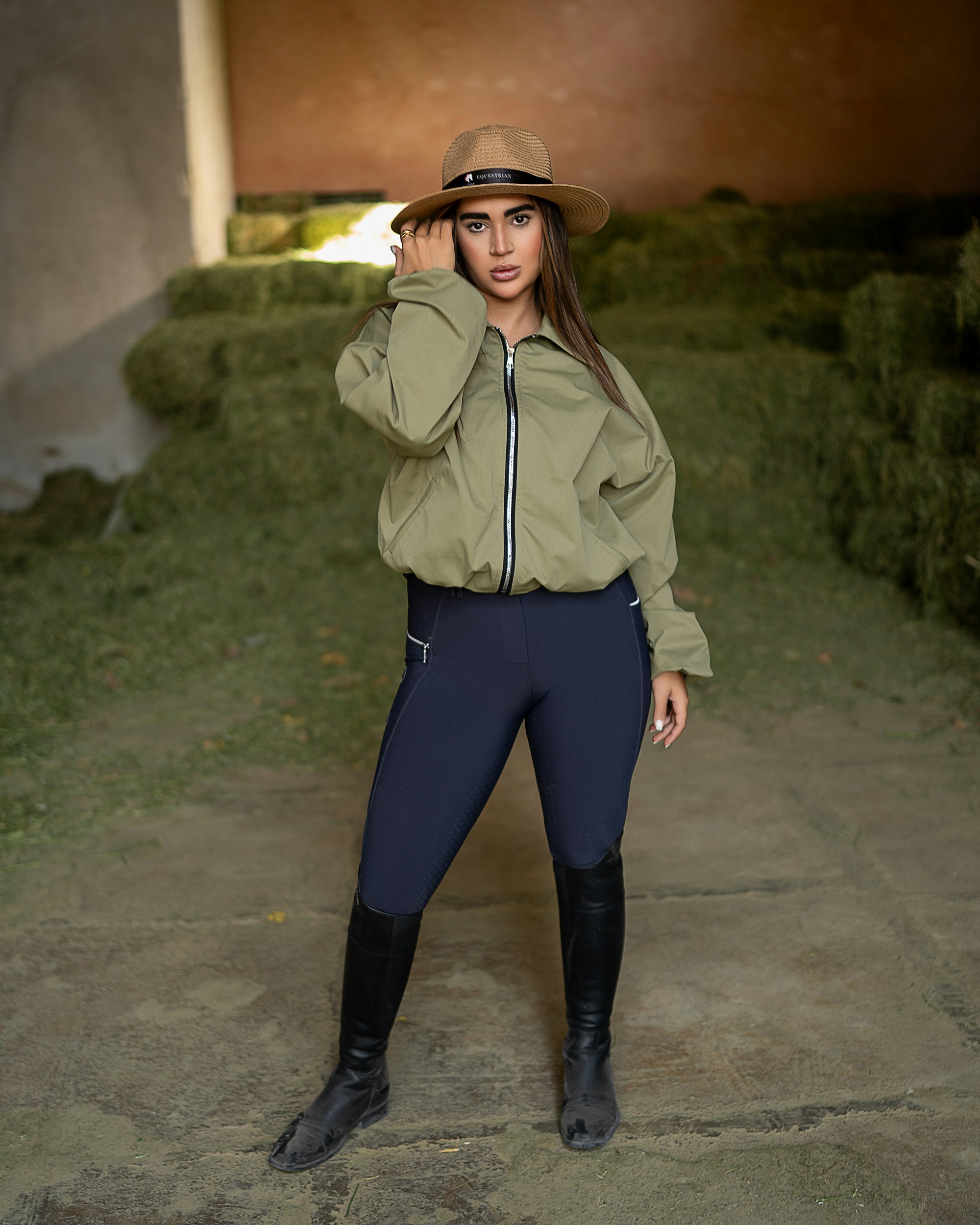 Woman in hat and riding gear in barn