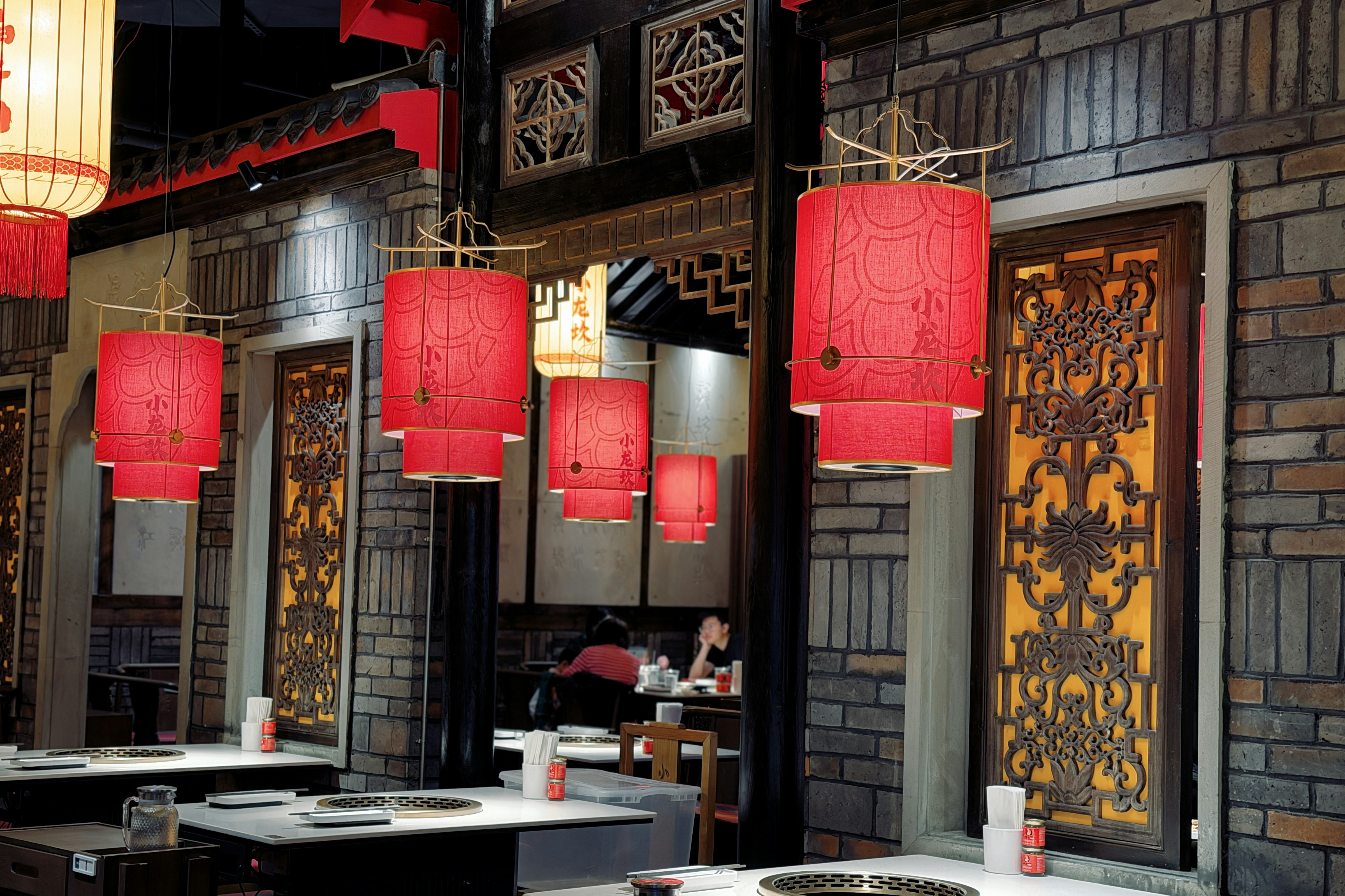 Red lanterns hang in a restaurant dining area.