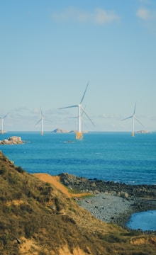 Offshore wind turbines stand in the blue ocean.