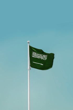 Saudi arabian flag waving against a clear blue sky