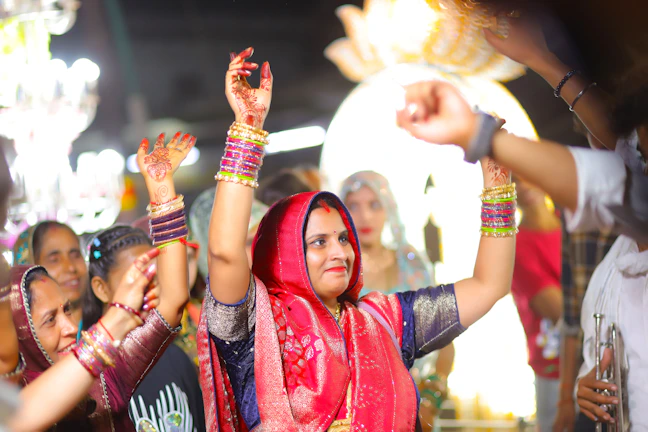 Women dancing with raised hands at a celebration.