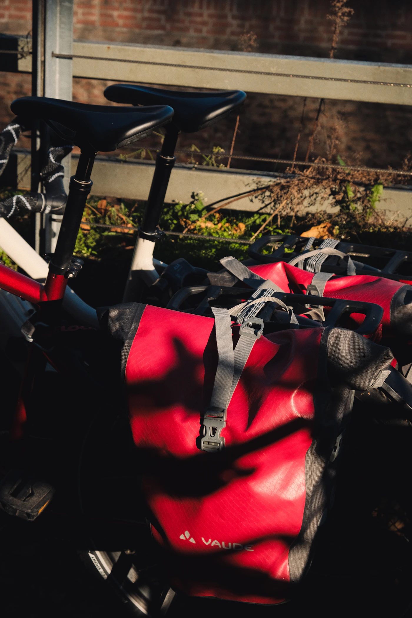 Bicycles equipped with large red rear pannier bags for carrying gear