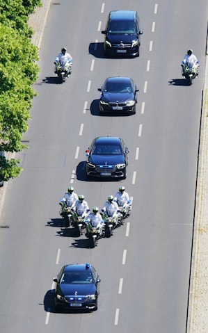 Motorcade with police escort on a city street.