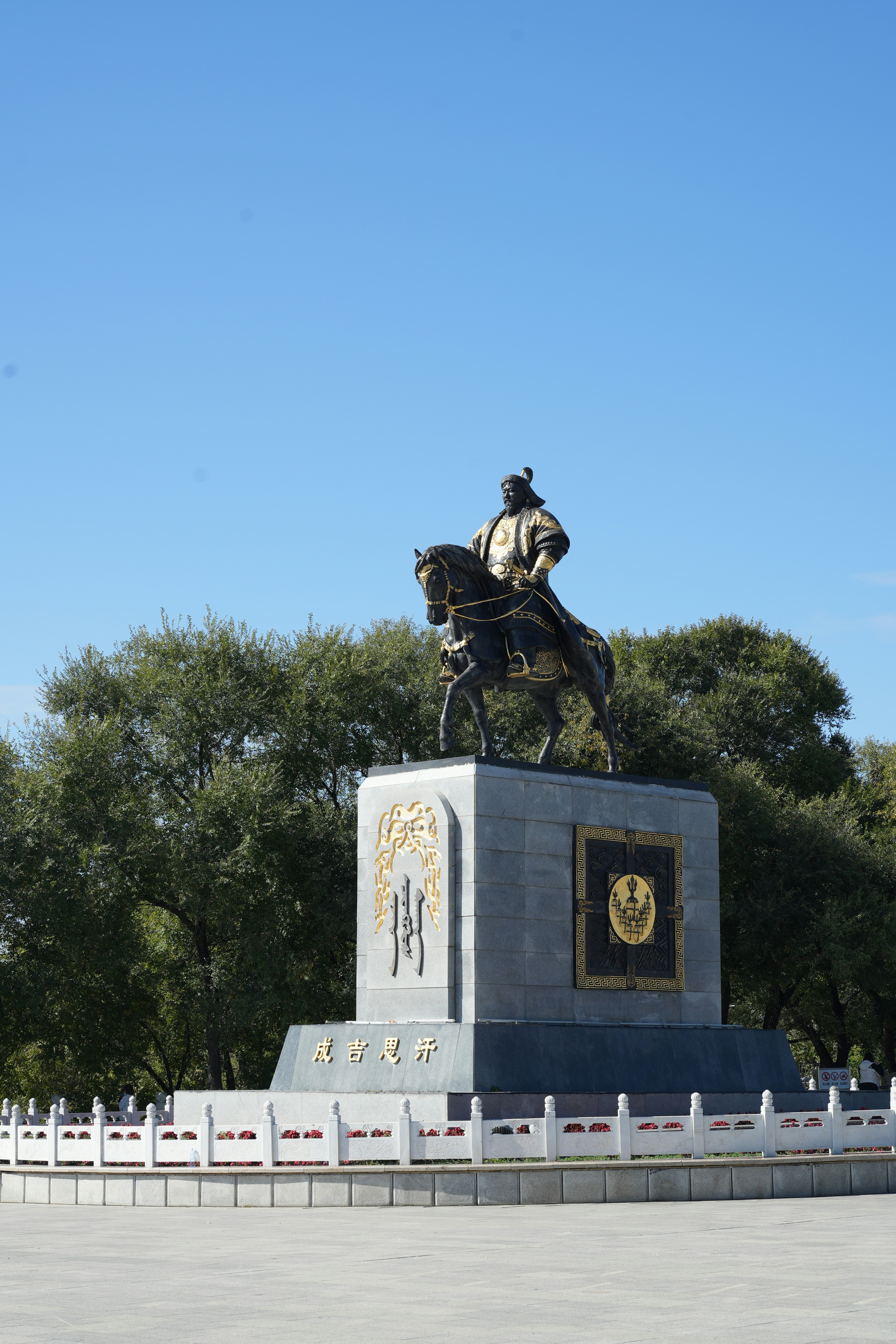 Estatua ecuestre en un pedestal con árboles detrás