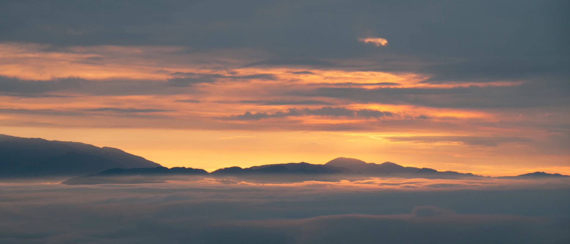 Clouds at sunset with orange and gray hues.