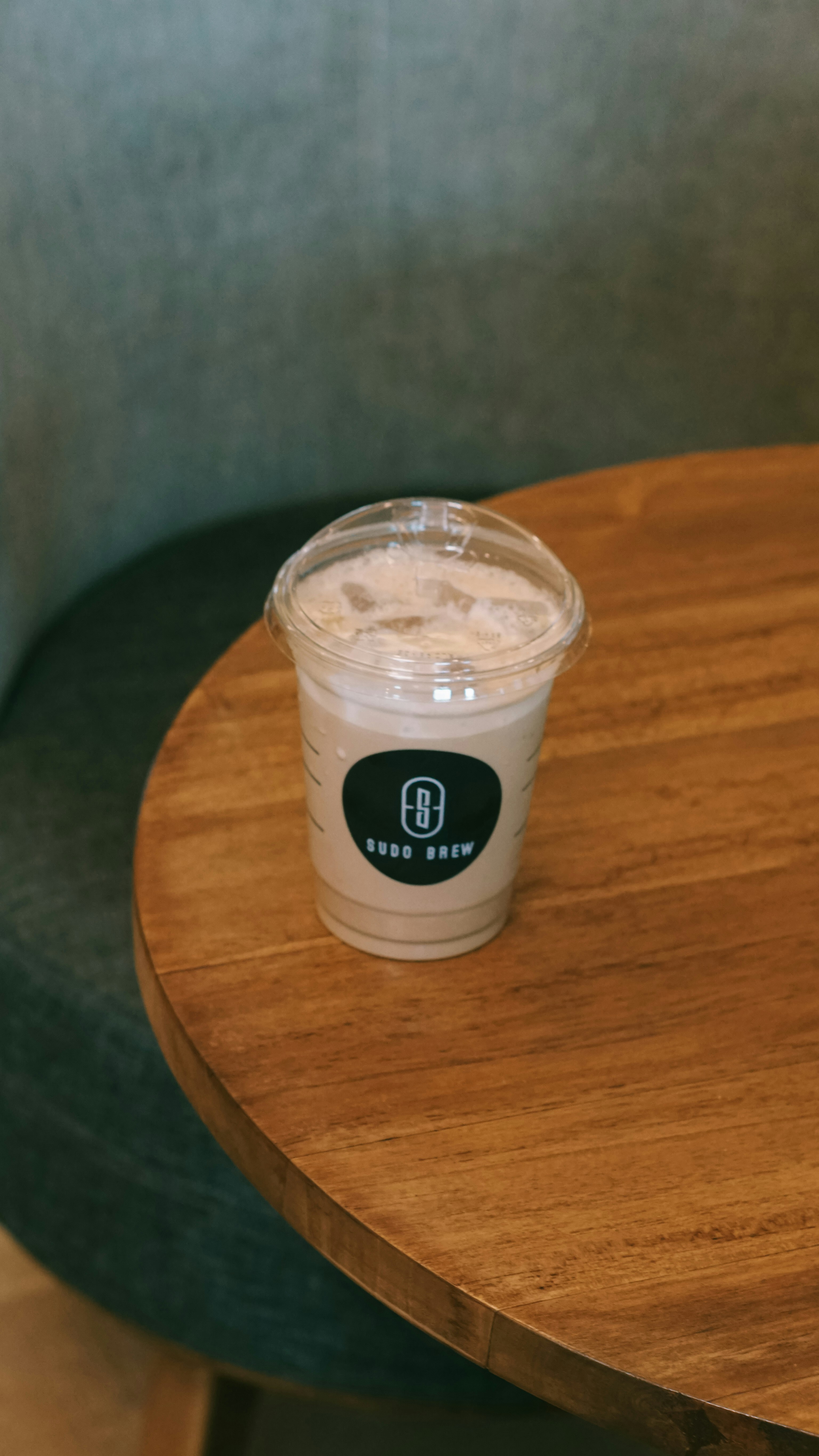 Iced coffee with logo on wooden table