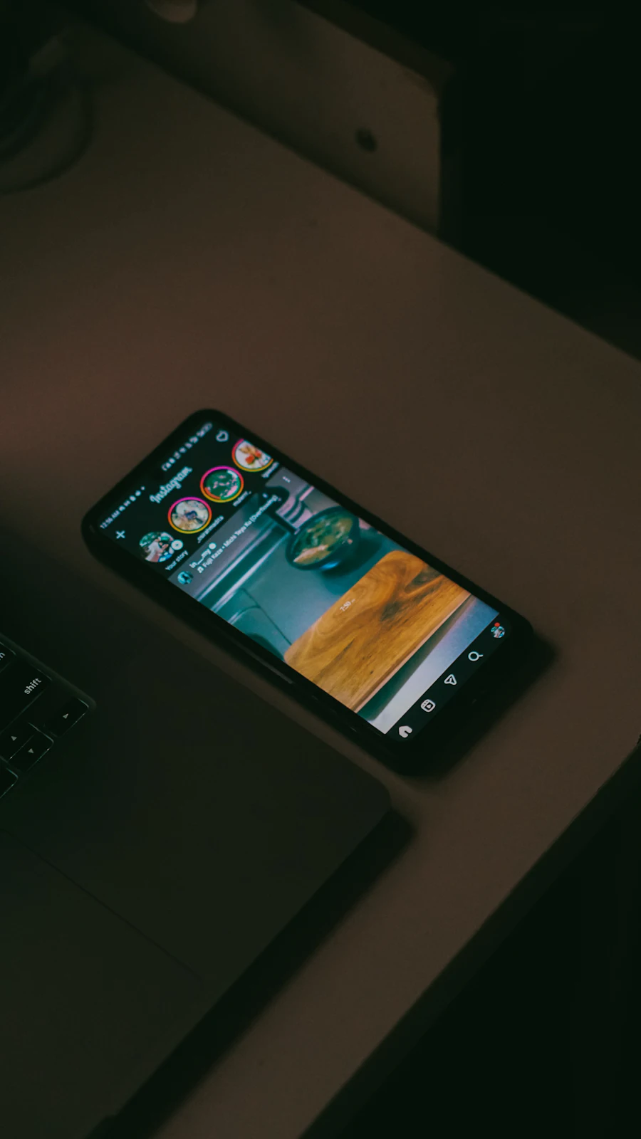 Smartphone showing a social media feed on a desk