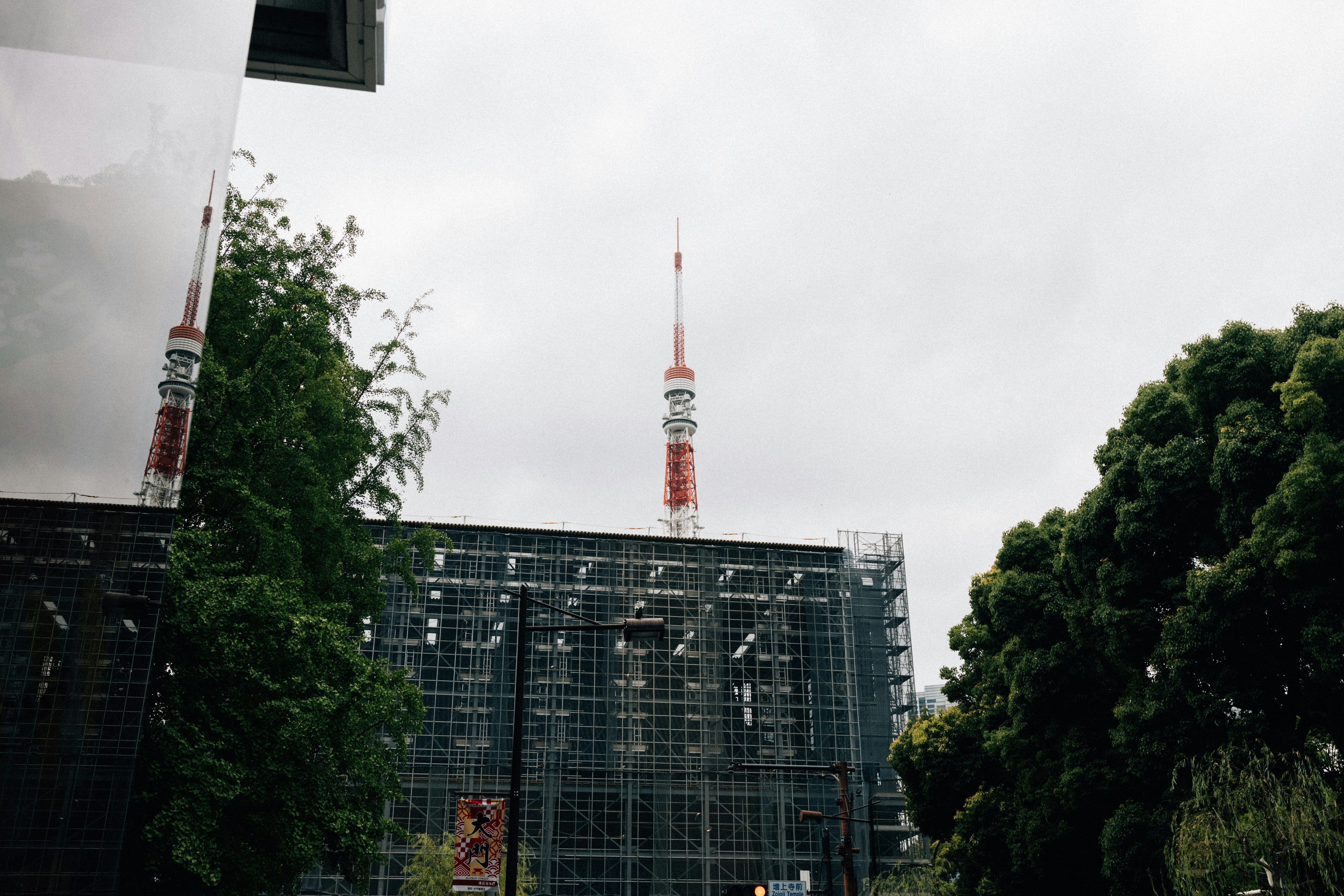 Tall tower rises above building under construction.