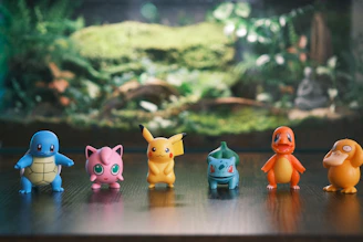 Six pokemon figurines lined up on a wooden surface
