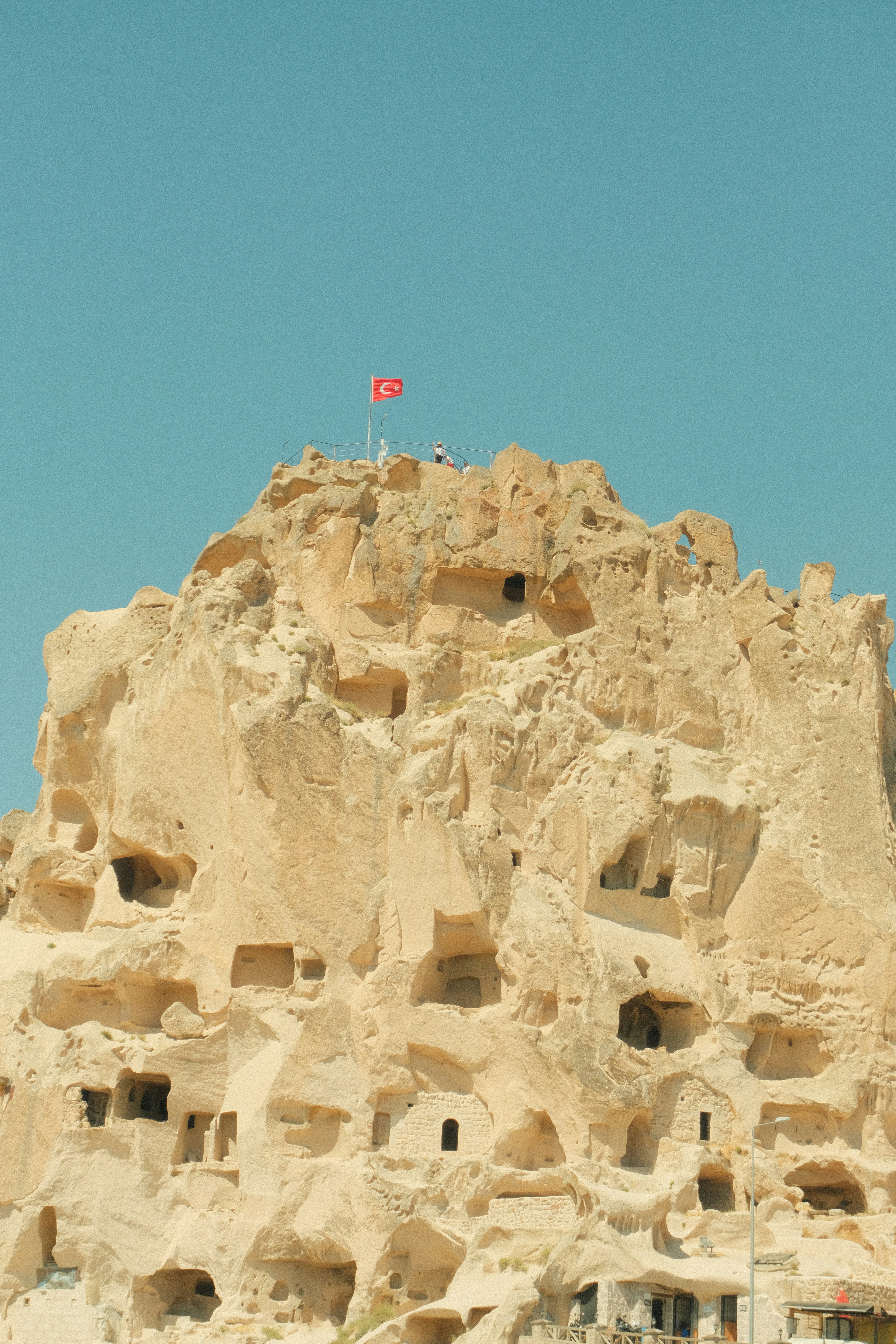 Castle carved into rock with turkish flag