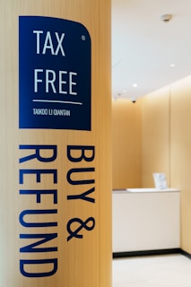 Tax free buy & refund sign on wooden pillar.