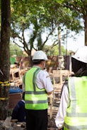 Workers in hard hats and safety vests at construction site.