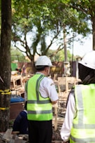 Workers in hard hats and safety vests at construction site.