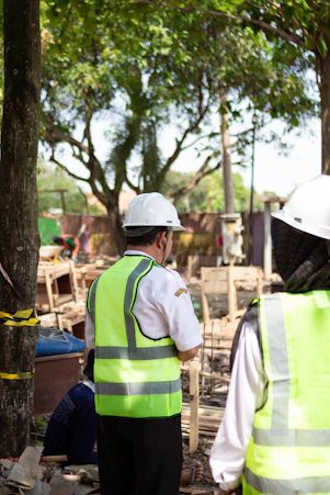Workers in hard hats and safety vests at construction site.