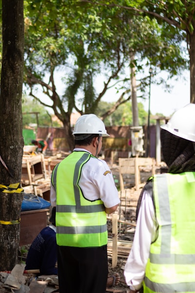 Workers in hard hats and safety vests at construction site.