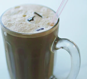 A tall glass of iced tea with a straw