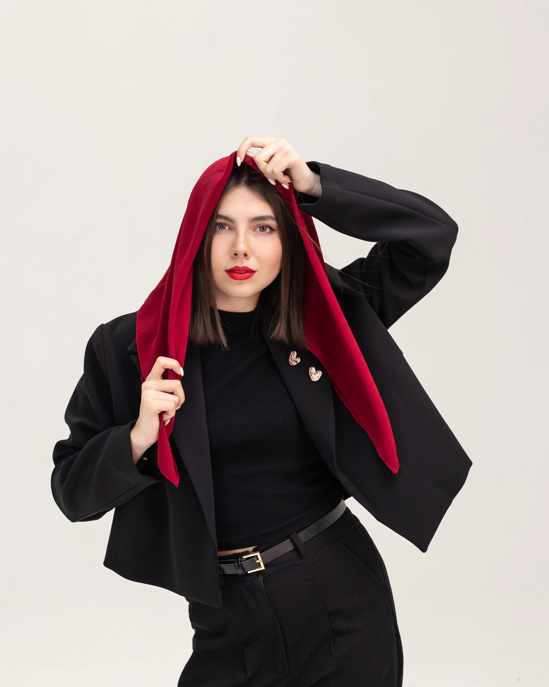 Woman in black blazer and red headscarf