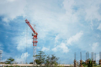 Construction crane against a cloudy blue sky.
