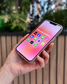 Hand holding smartphone with social media apps