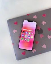 Smartphone displaying social media apps on laptop.