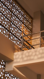 Ornate geometric screen with sunlight and shadows.