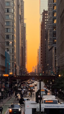 City street with traffic and buildings at sunset