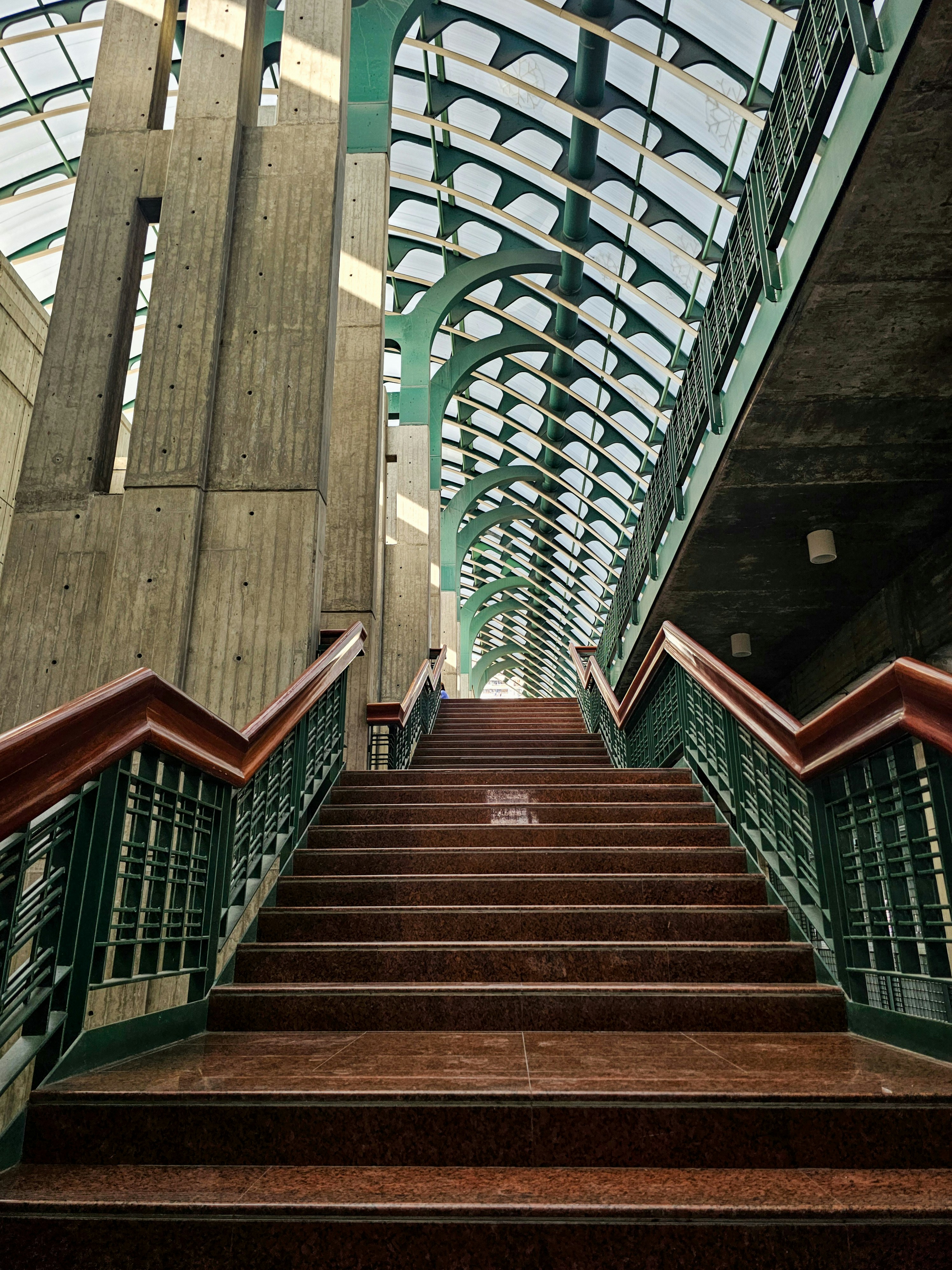 Modern staircase with glass ceiling and concrete walls