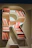 Books arranged on a letter r shaped bookshelf.