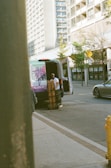 Man unloading boxes from a van on a city street.