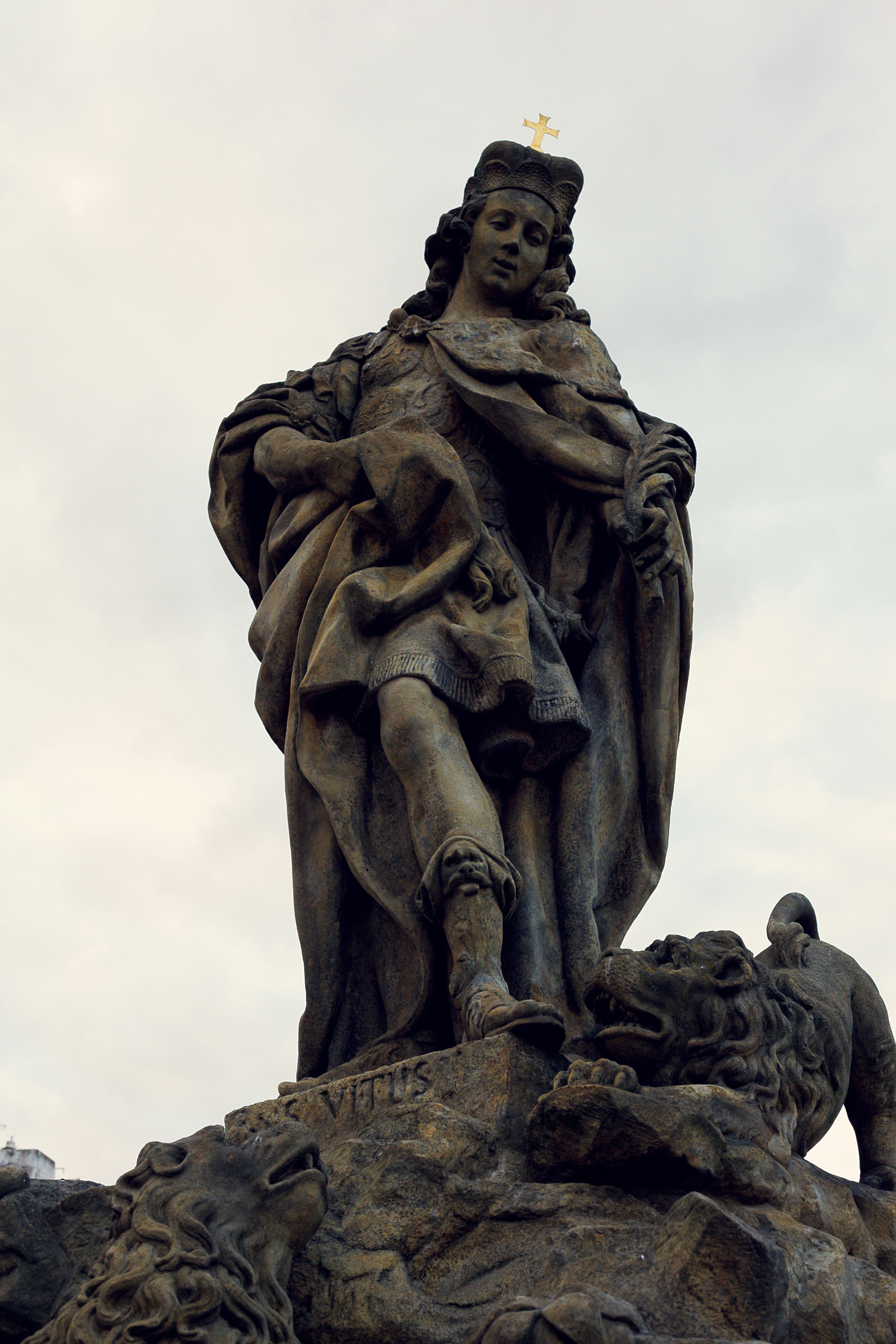 Statue of saint vitus with lions against a cloudy sky