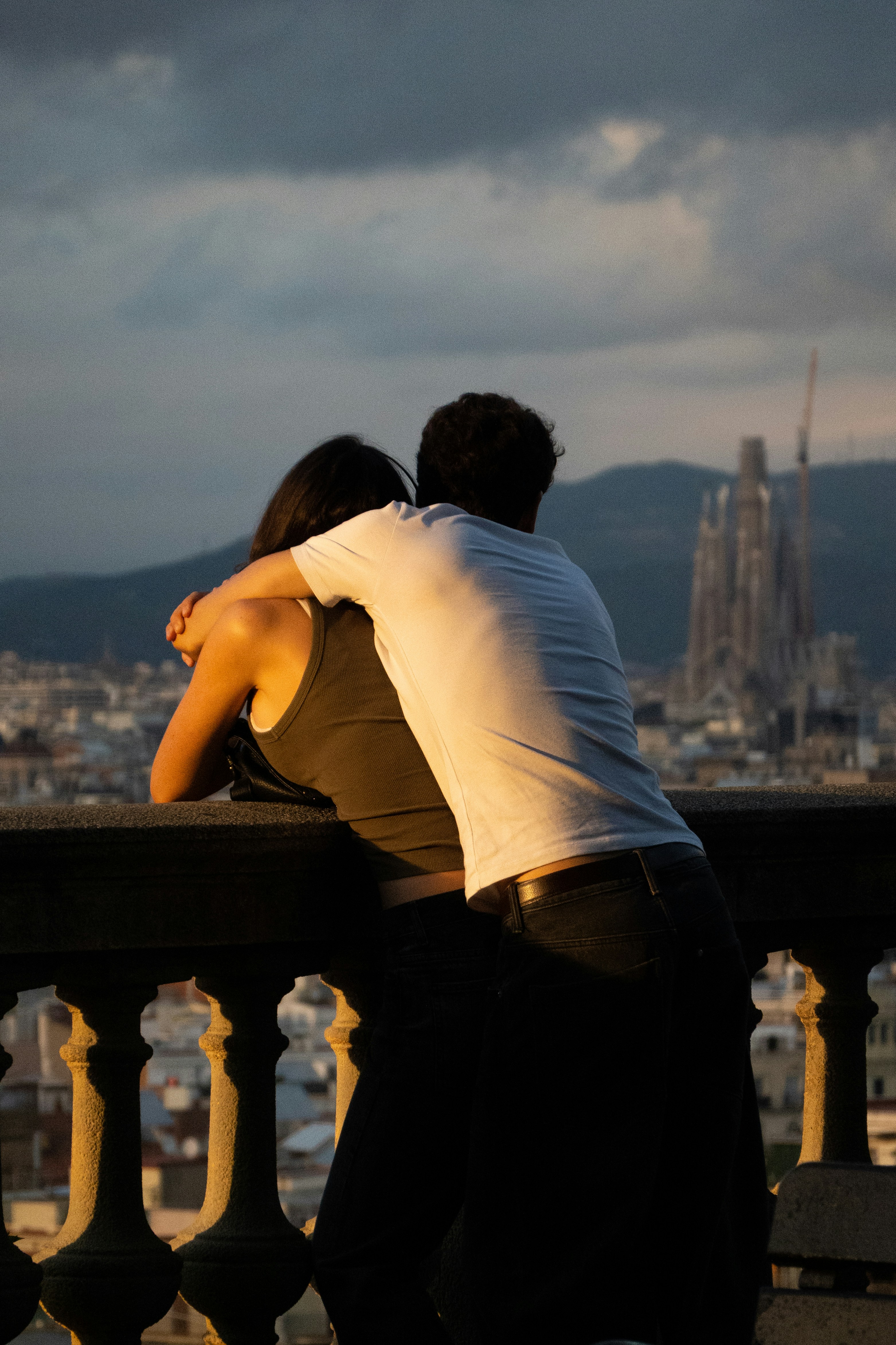 Couple embracing on balcony overlooking city skyline