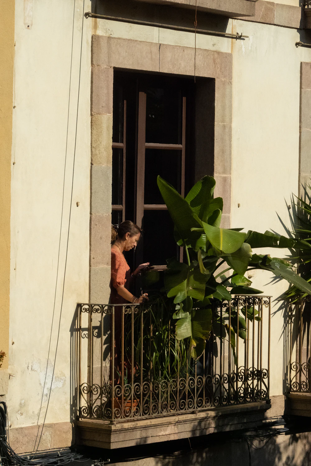 Woman tending plants on a balcony
