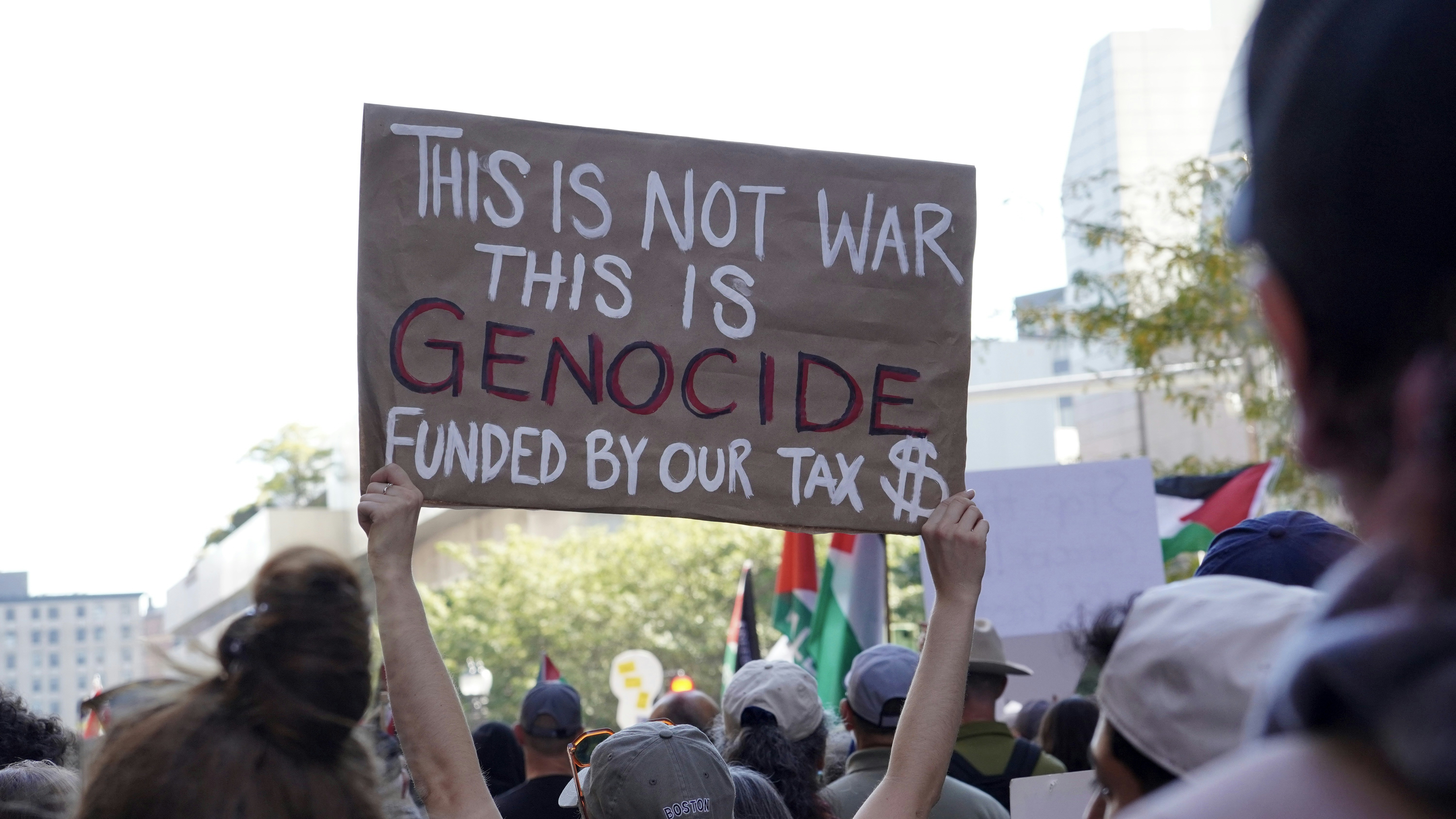Protest sign reads 'this is not war, this is genocide'.