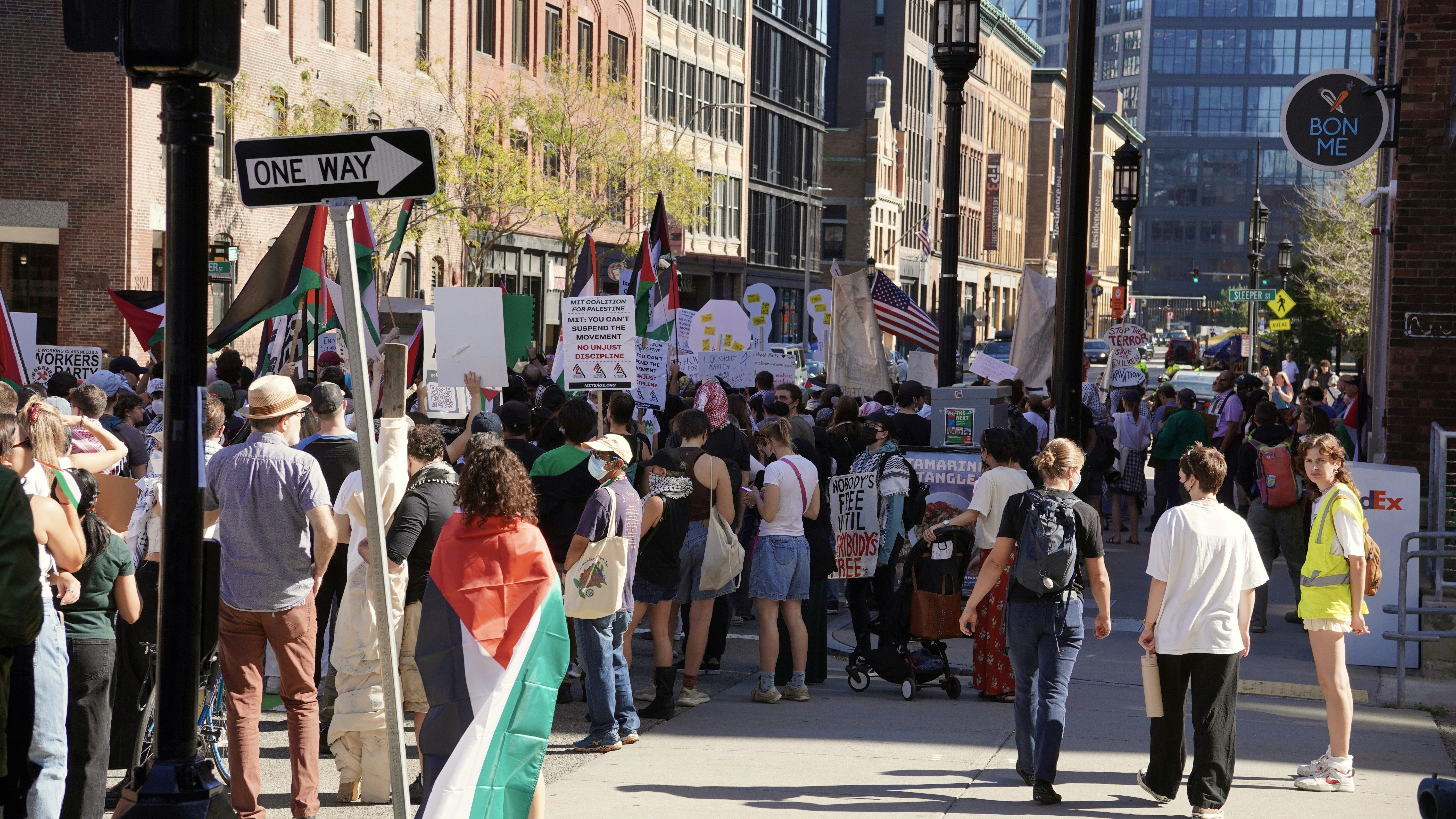 Protesters with palestinian flags marching on city street