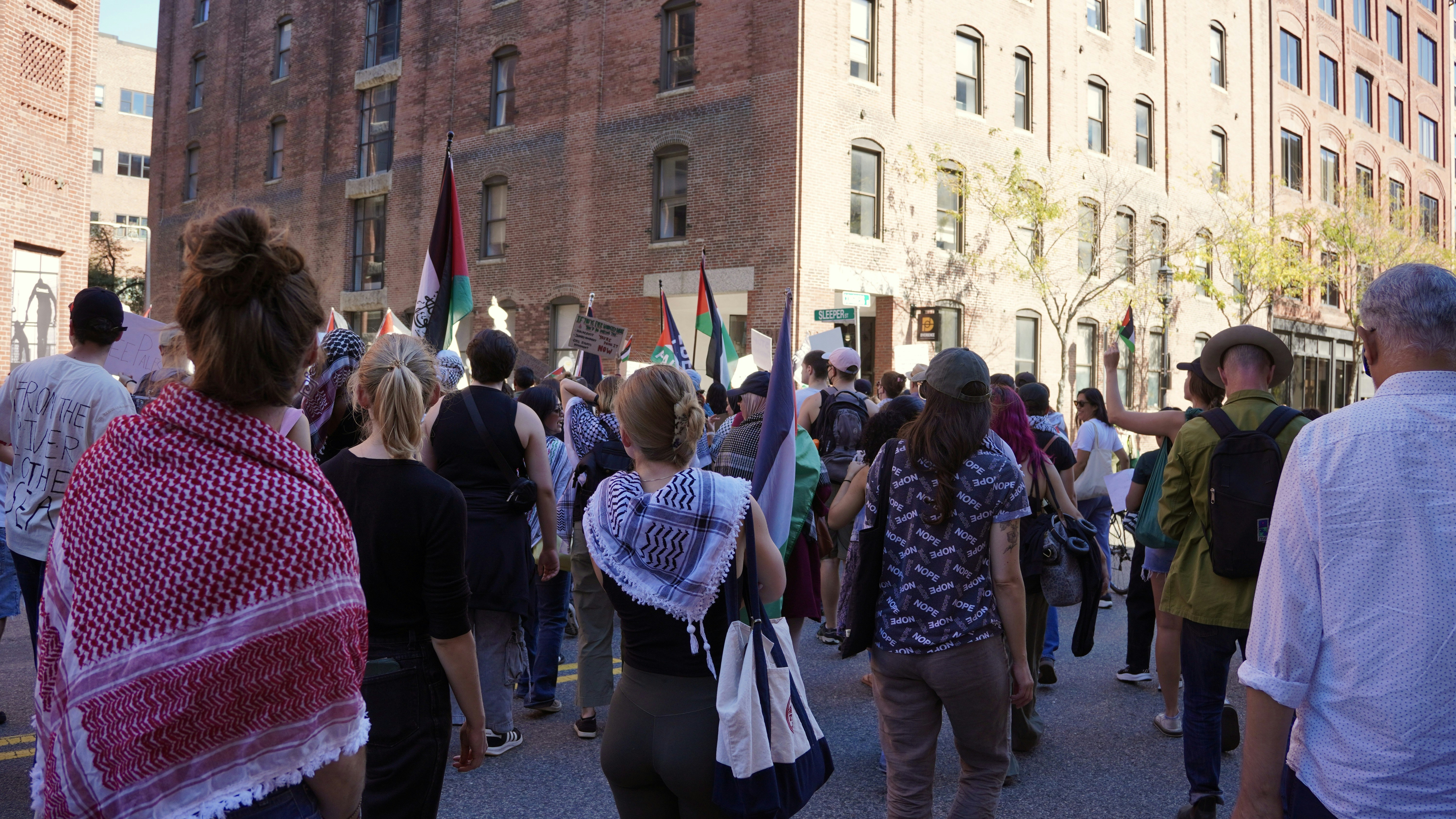 People marching with flags in a city street