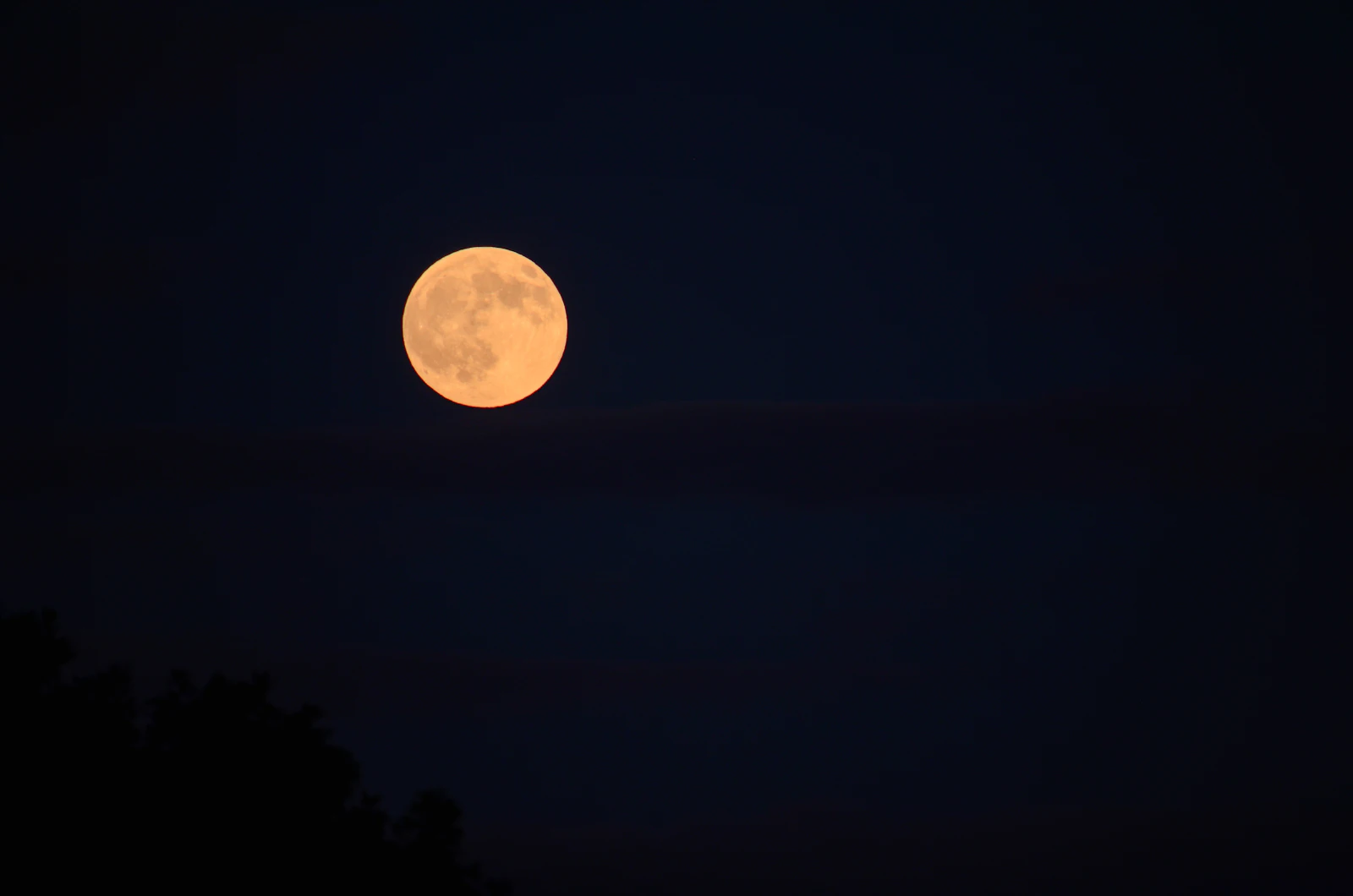 Full moon glowing brightly in the dark night sky