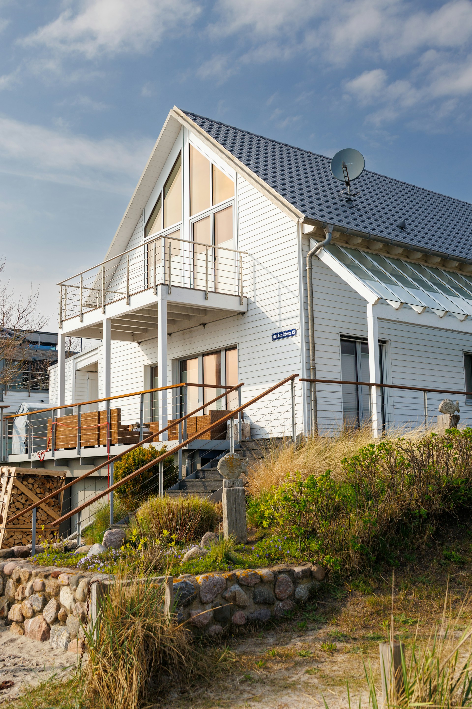 Modern white house with balconies and beach grass