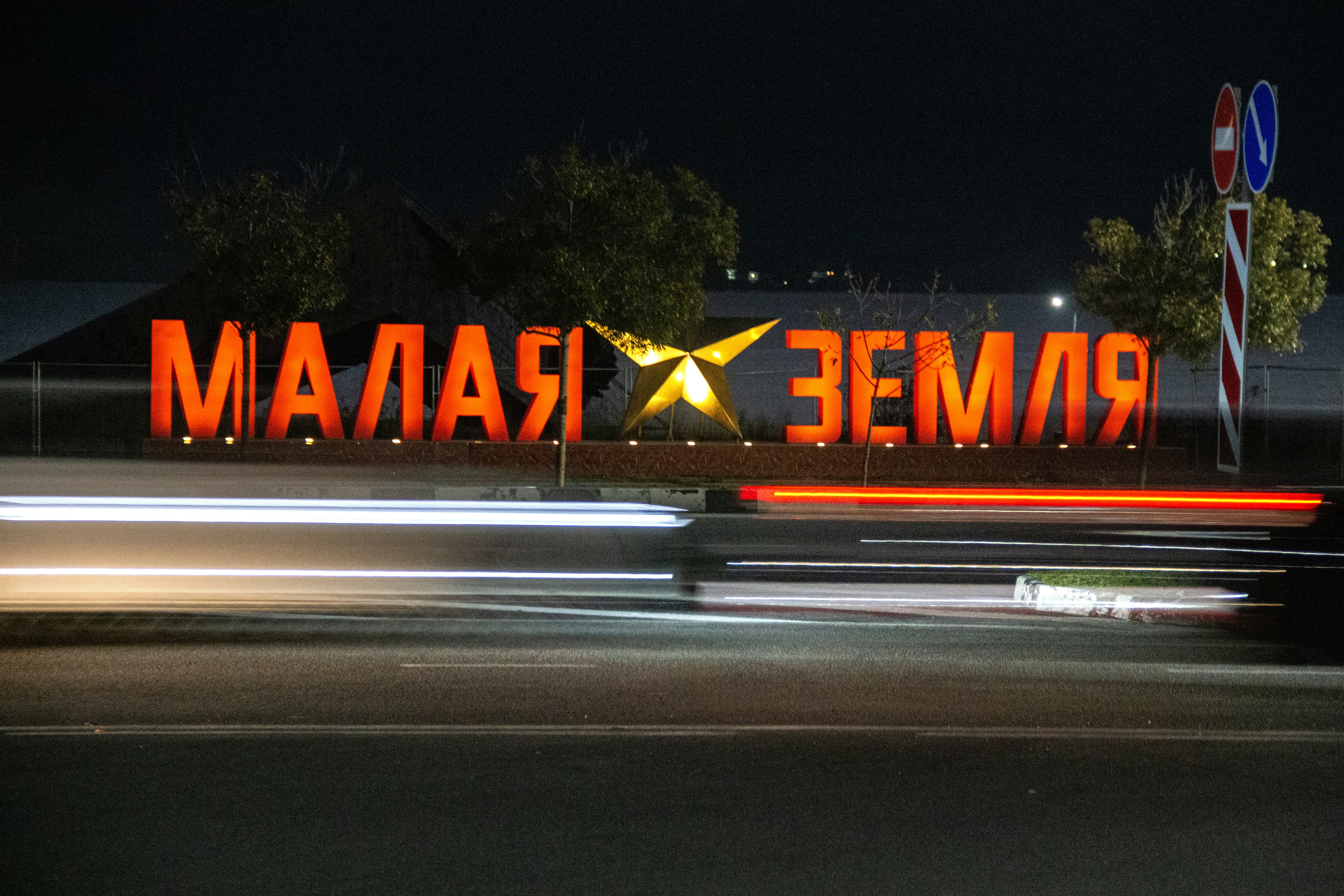 Large illuminated sign at night with light streaks