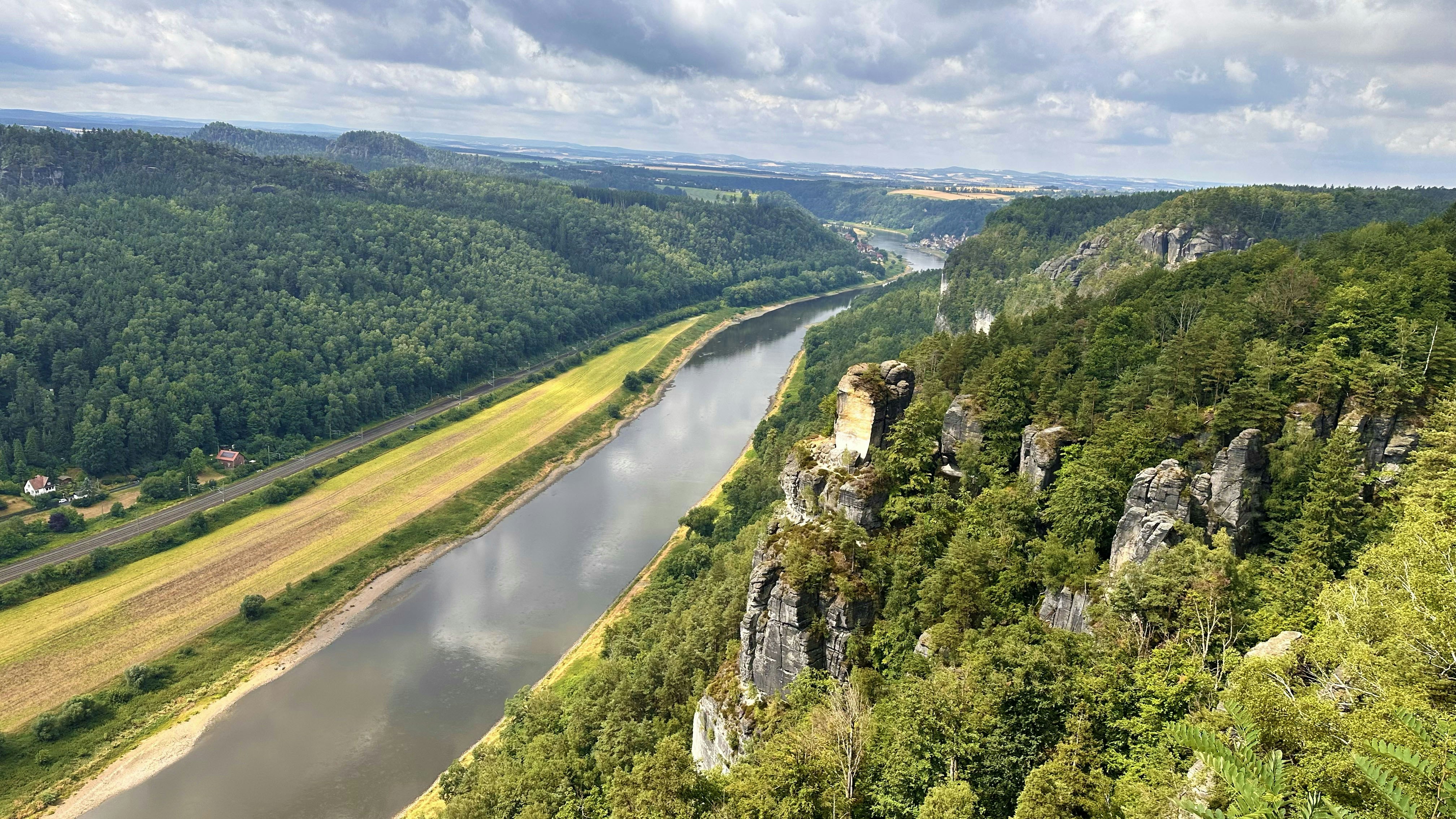 River flowing through a lush green valley with rocky cliffs.