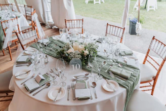 Round table set for a formal event with floral centerpiece.