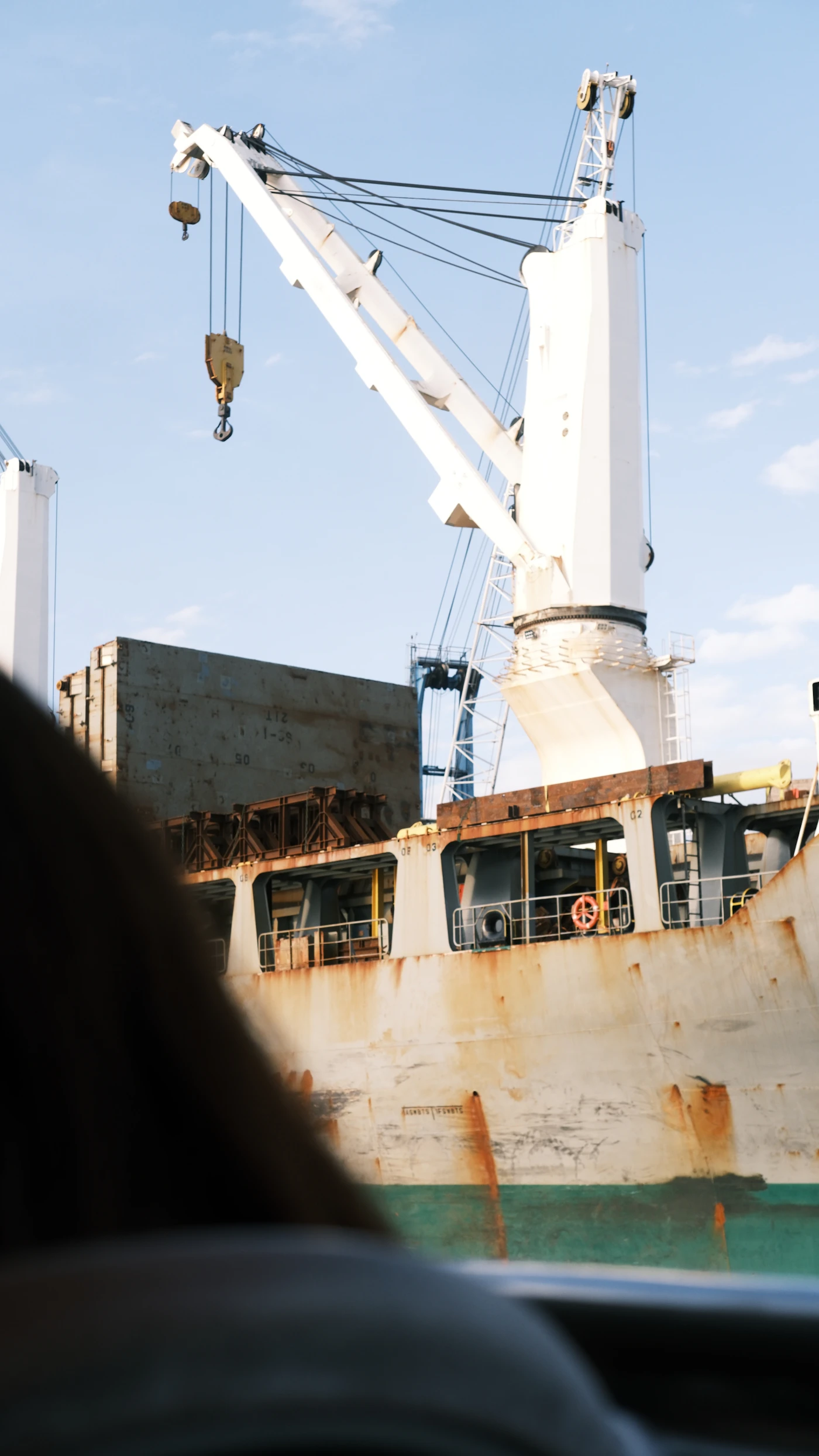 A close-up of a cargo ship crane at dockside, representing the dock and terminal workers who typically qualify for LHWCA benefits