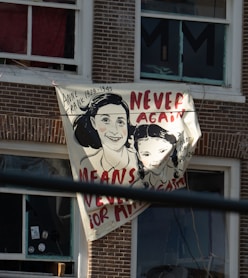 Anne frank banner with 'never again' slogan