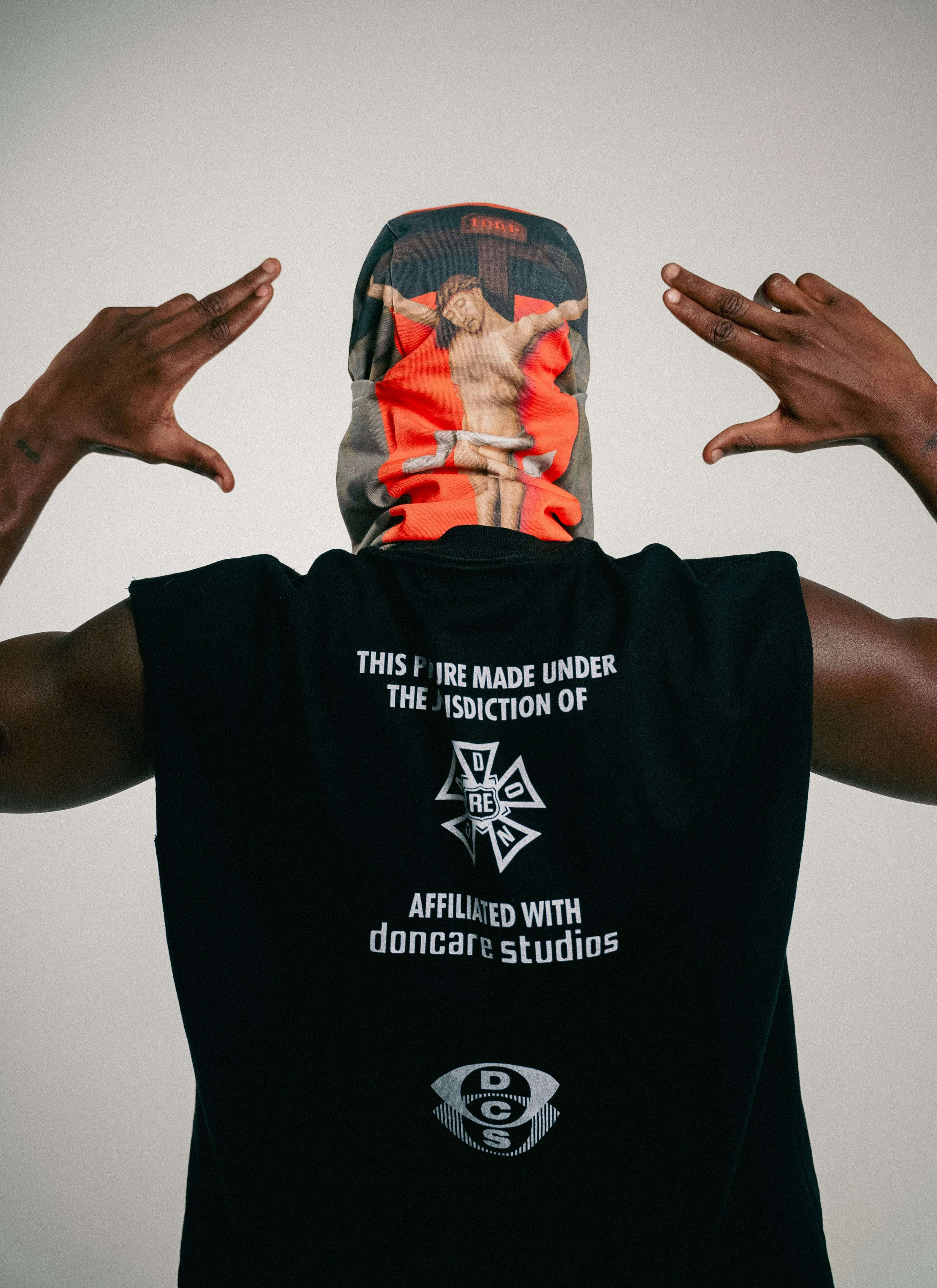 Person wearing a shirt and mask with religious imagery.