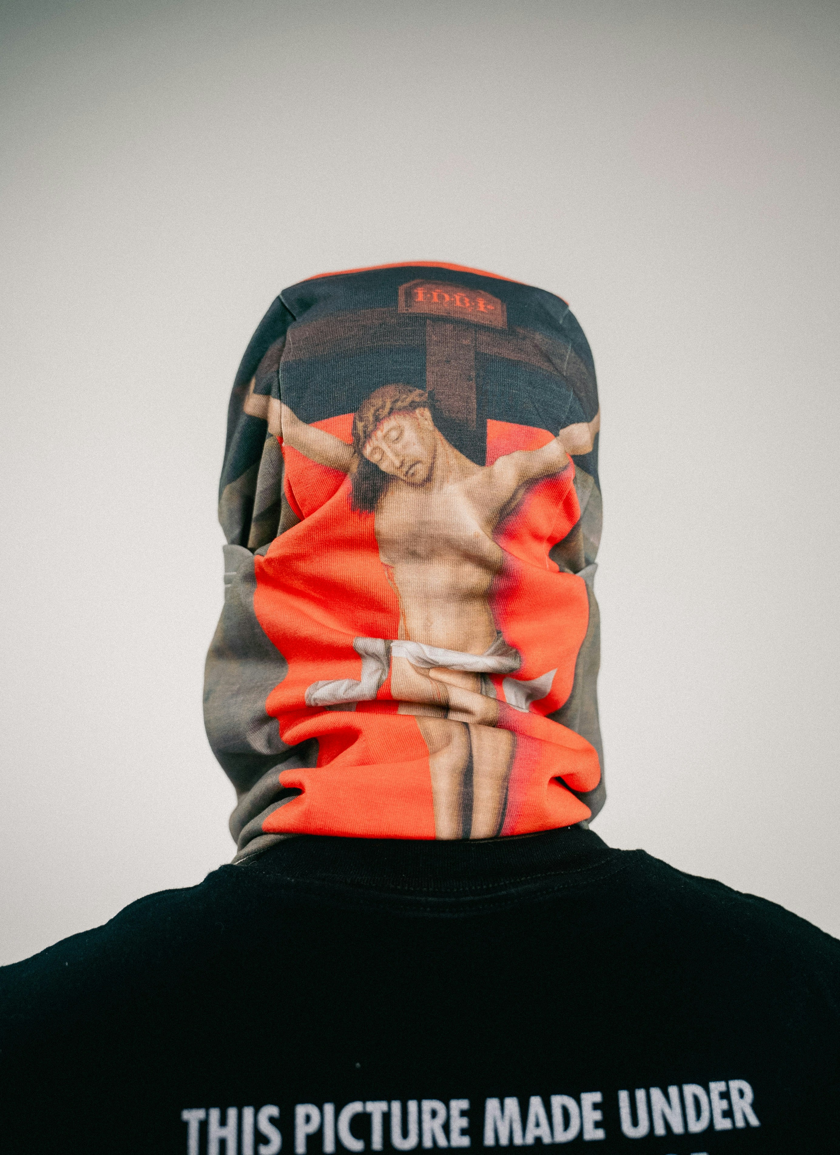 Person wearing a balaclava with jesus crucifixion graphic.