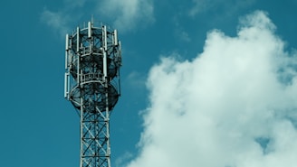 Cell tower against a cloudy blue sky