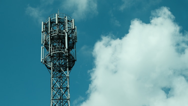 Cell tower against a cloudy blue sky