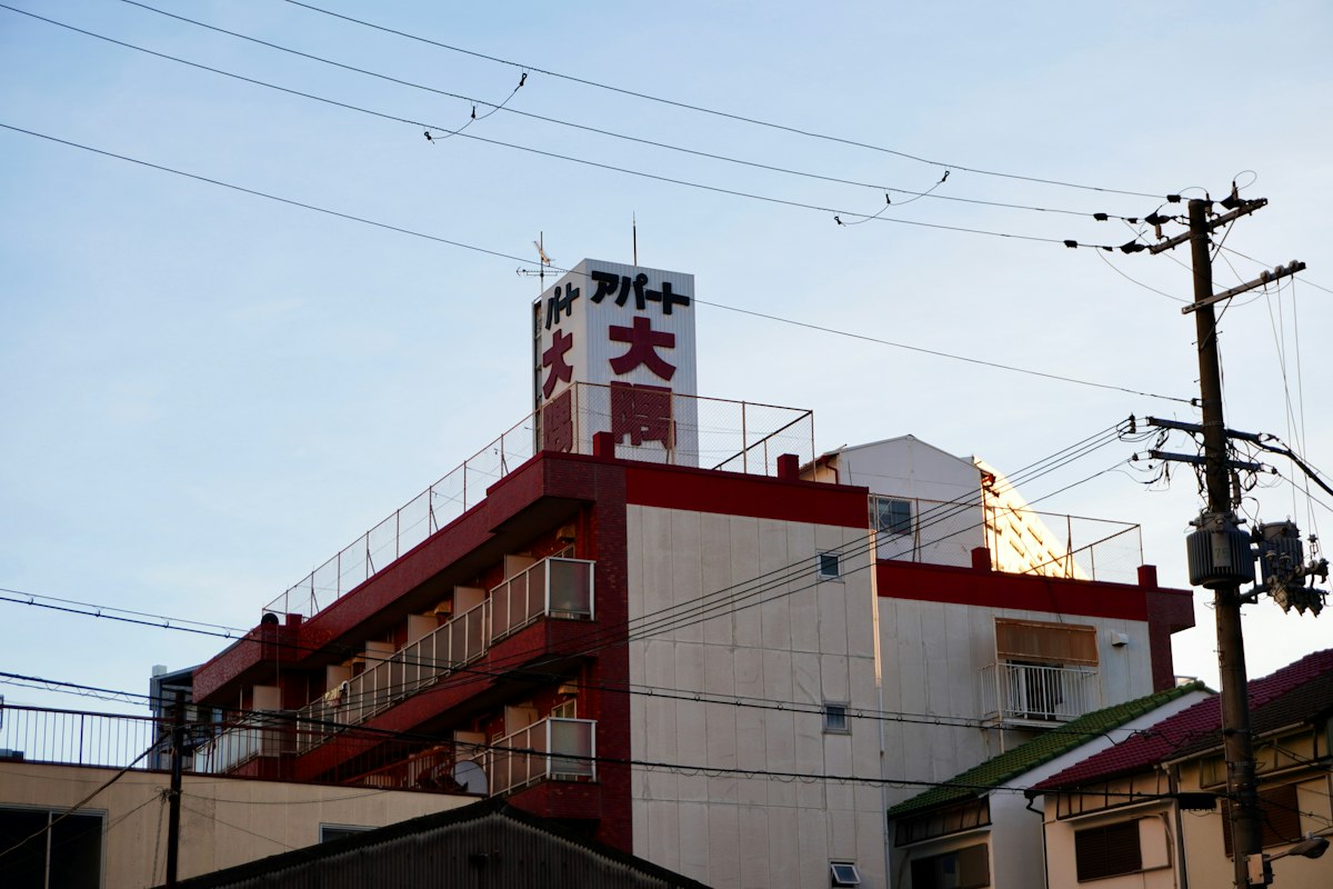 赤い縁取りと日本語の看板がある低層の建物