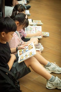 Children reading books together on the floor.