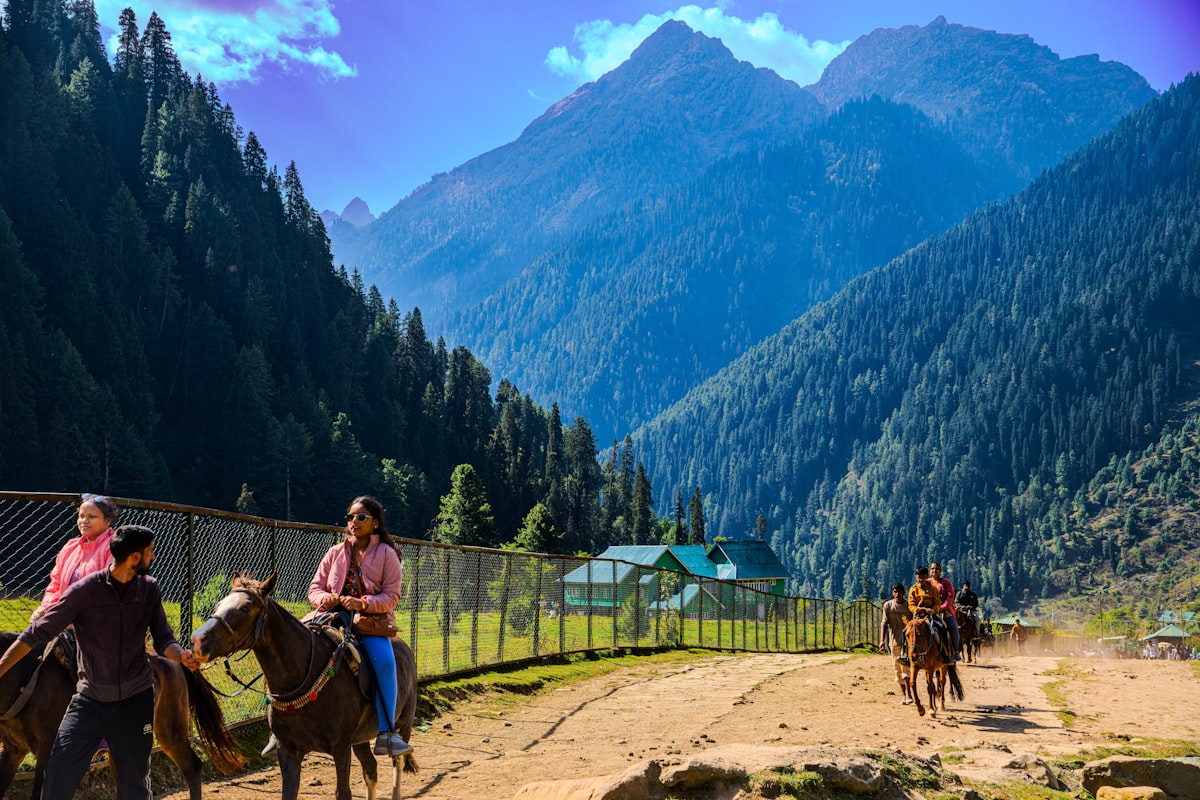 Horse riders on a scenic mountain trail path
